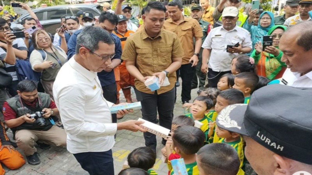 Penjabat (Pj) Gubernur DKI Jakarta, Heru Budi Hartono membagikan sejumlah kotak pensil kepada anak-anak PAUD yang menyambut kedatangannya di Kelurahan Pekojan, Tambora, Jakarta Barat, Rabu (11/10/2023). (ANTARA/Risky Syukur)