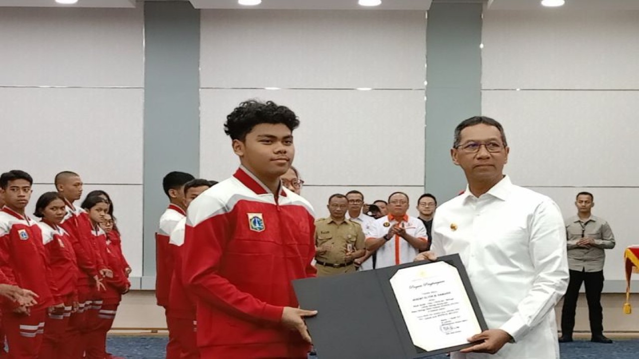 Penjabat (Pj) Gubernur DKI Jakarta Heru Budi Hartono memberikan penghargaan kepada atlet DKI Jakarta yang bertanding pada pekan POPNAS ke-XVI Sumatera Selatan di Balai Kota DKI Jakarta, Selasa (17/10/2023). ANTARA/Siti Nurhaliza