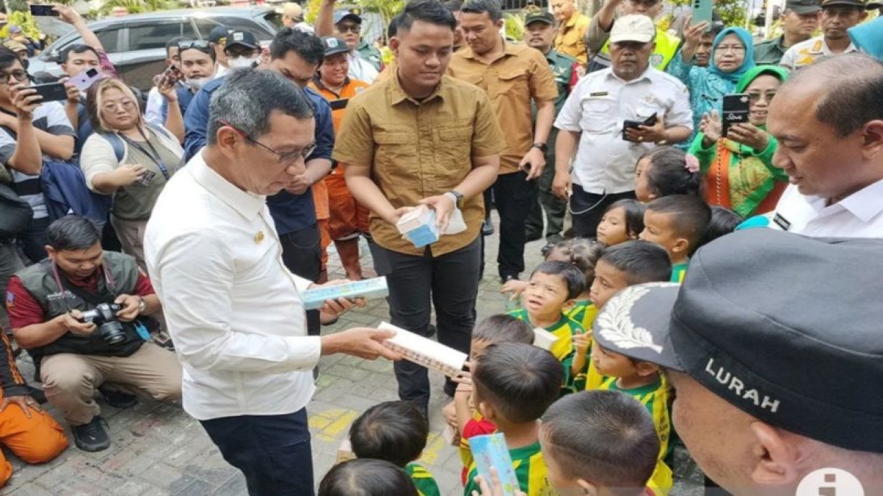 Penjabat (Pj) Gubernur DKI Jakarta, Heru Budi Hartono membagikan sejumlah kotak pensil kepada anak-anak PAUD yang menyambut kedatangannya di Kelurahan Pekojan, Tambora, Jakarta Barat, Rabu (11/10/2023). (ANTARA/Risky Syukur)