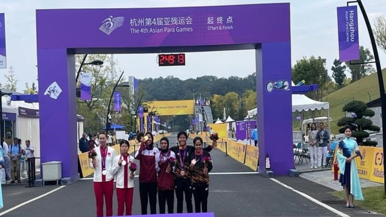 Atlet balap sepeda Putri NPC Indonesia Sri Sugiyanti dan Nimal Magfiroh (tengah) saat menerima medali emas nomor road race putri, di Chunan Jienshou Sports Centre Hangzhou, China, Jumat (27/10/2023). ANTARA/HO- Humas NPC Indonesia.