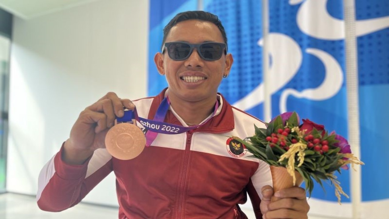 Atlet Para atletik Indonesia Jaenal Aripin berpose dengan medali perunggu yang ia raih di nomor balap kursi roda (wheelchair race) 100 meter T54 putra, di Huanglong Sports Centre Stadium, China, Rabu (25/10/2023). (ANTARA/Arnidhya Nur Zhafira)