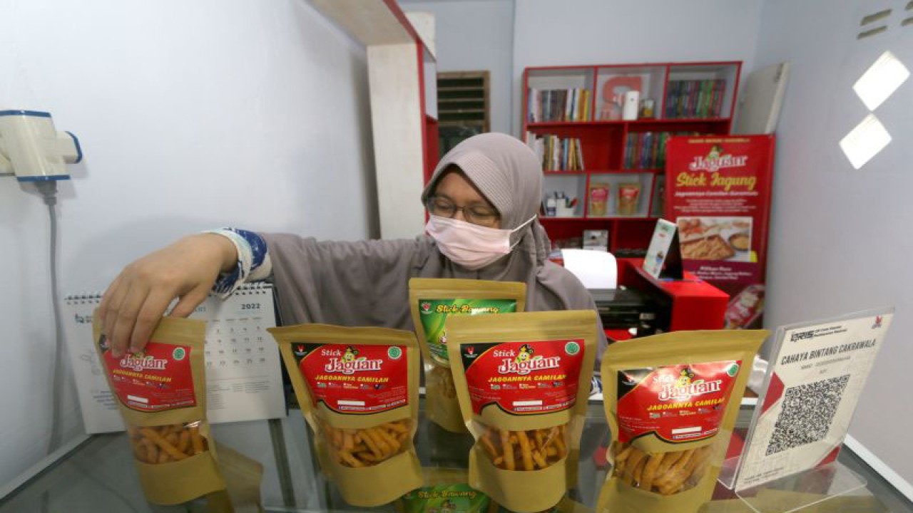 Pemilik UMKM merapikan produk olahan jagung di rumah produksi stik Jaguan di Kota Gorontalo, Gorontalo, Jumat (18/2/2022). ANTARA FOTO/Adiwinata Solihin/aww.