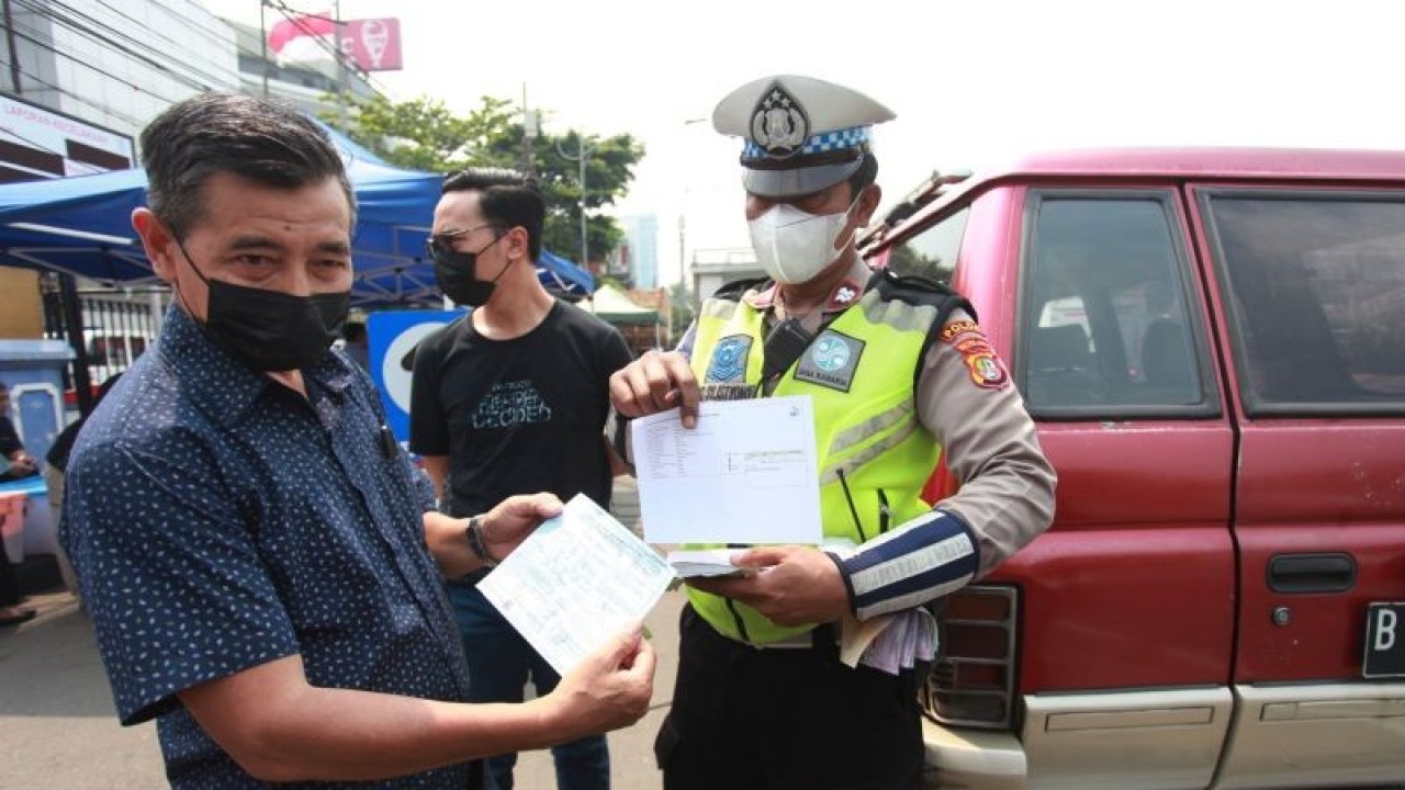 Petugas menilang pengendara kendaraan tak lolos uji emisi di Subdit Gakkum Ditlantas Polda Metro Jaya, Jakarta, Jumat (1/9/2023). Direktorat Lalu Lintas Polda Metro Jaya bersama Dinas Lingkungan Hidup DKI Jakarta mulai memberlakukan tilang uji emisi pada kendaraan roda dua dan roda empat sebagai upaya mendorong masyarakat berkontribusi dalam mengatasi masalah buruknya kualitas udara di Ibu Kota dan menerapkan denda sanksi tilang bagi kendaraan tak lolos uji emisi sebesar Rp250.000 bagi motor dan Rp500.000 untuk mobil. ANTARA FOTO/Reno Esnir/aww.