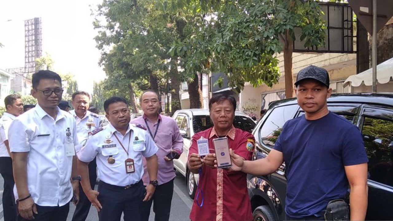 Penjabat Sekda Kudus Revlisianto Subekti didampingi Kepala Dishub Kudus Catur Sulistiyanto melihat praktik pembayaran parkir dengan QR code (quick response code) di Jalan A.Yani Kudus, Kamis (26/10/2023). (ANTARA/Akhmad Nazaruddin Lathif)