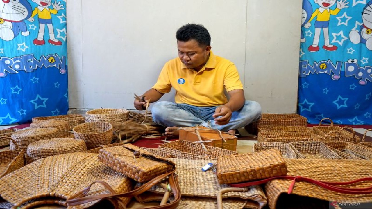 Seorang perajian membuat kotak hiasan dari berbahan eceng ondok di Kabupaten Gorontalo, Gorontalo, Senin (2/10/2023). . ANTARA FOTO/Adiwinata Solihin/tom (ANTARAFOTO/Adiwinata Solihin)