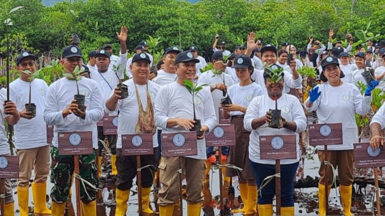 Peserta kegiatan penanaman bibit pohon mangrove berfoto bersama di area sekitar Jembatan Youtefa, Kota Jayapura, Provinsi Papua, Selasa (31/10/2023). (ANTARA/Ardiles Leloltery)