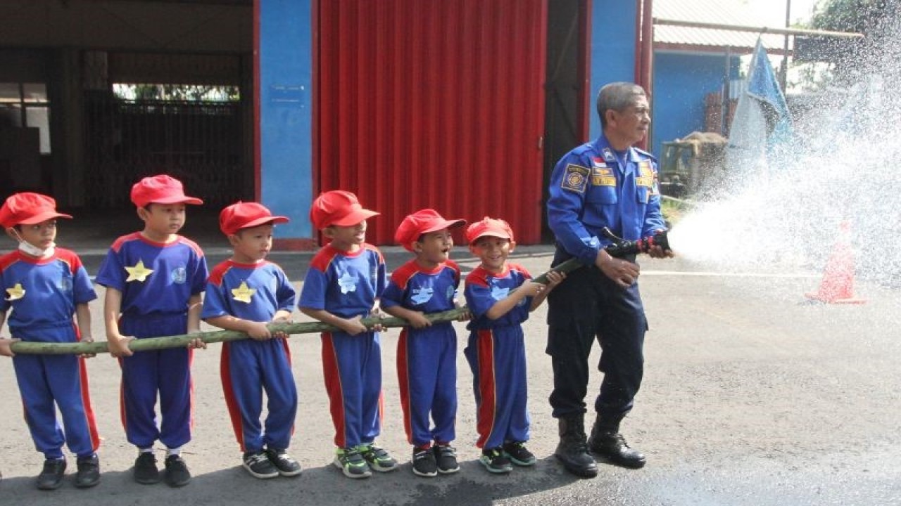 Petugas pemadam kebakaran menyemprotkan air bersama siswa Taman Kanak-kanak dalam Edukasi Mitigasi Bencana Kebakaran di Markas Pemadam Kebakaran Kota Malang, Jawa Timur, Rabu (18/10/2023). ANTARA FOTO/Ari Bowo Sucipto/aww. (ANTARA FOTO/ARI BOWO SUCIPTO)