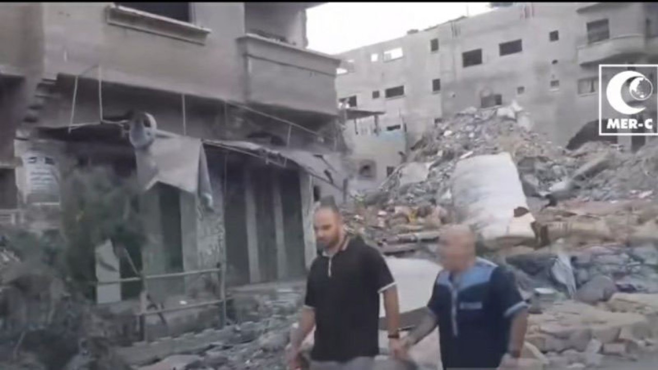 Tangkapan layar - Rekaman video tim MER-C menunjukkan dua warga Palestina berjalan melalui bangunan-bangunan yang runtuh di Gaza pada Selasa (24/10/2023). (ANTARA/Katriana)