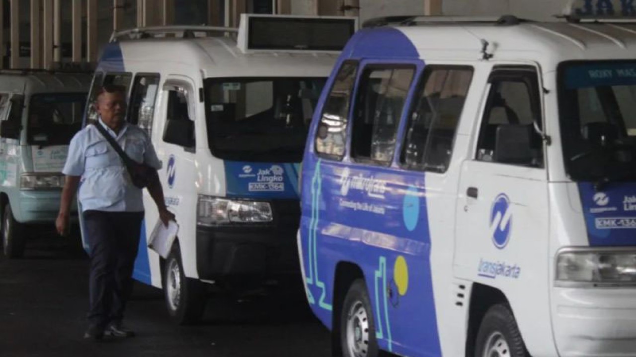 Seorang pengemudi berjalan di samping angkutan Mikrotrans yang terparkir di Tanah Abang, Jakarta, Kamis (12/10/2023). ANTARA FOTO/Suci Nurhaliza/sgd/Spt