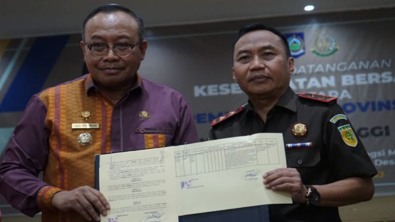 Kepala Kejati NTB Nanang Ibrahim Soleh (kanan) bersama Pj. Gubernur NTB Lalu Gita Ariadi menunjukkan dokumen kesepakatan kerja sama program Jaksa Garda Desa untuk mengawal pembangunan desa di Mataram, Selasa (24/10/2023). (ANTARA/Dhimas B.P.)