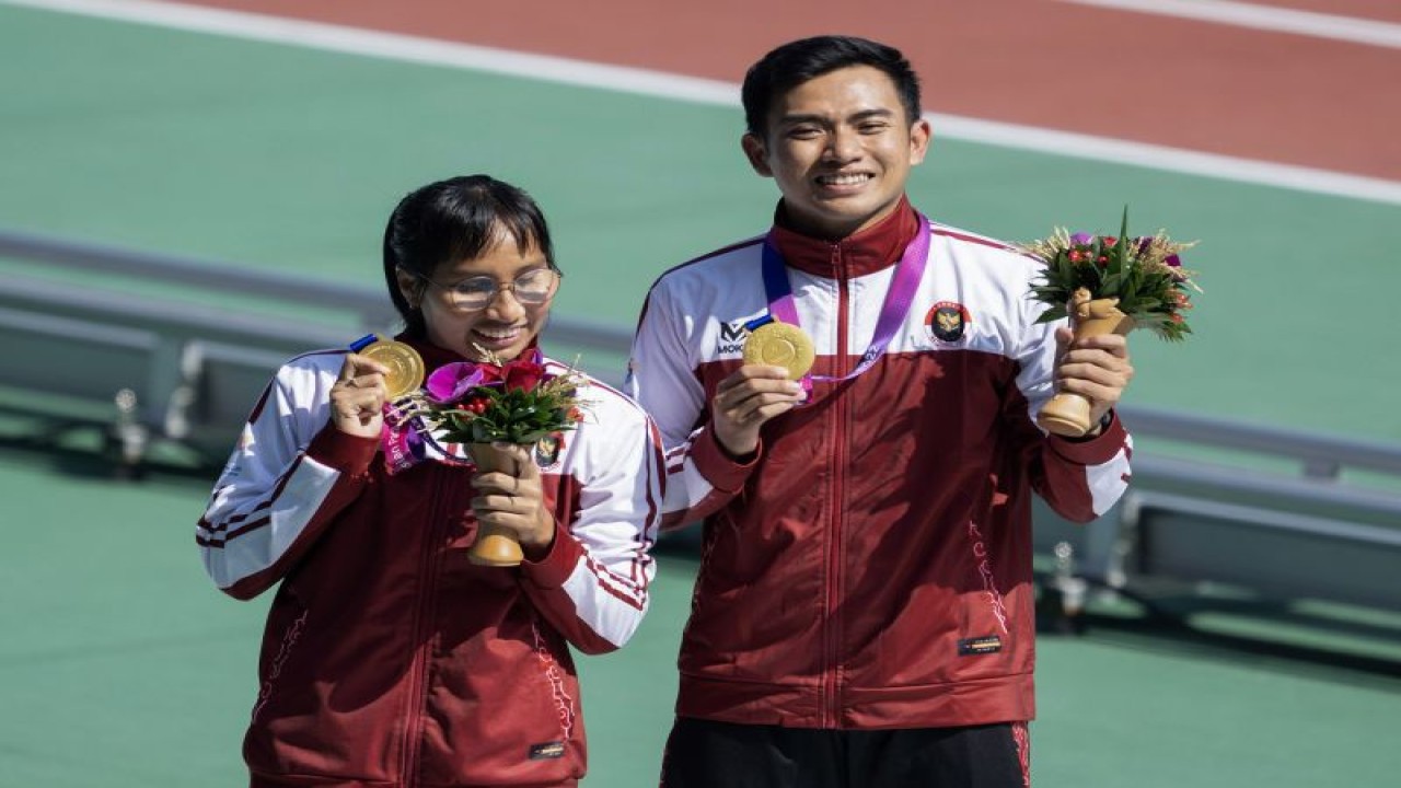 Ni Made Arianti Putri (kiri) memamerkan medali emas yang diarih dari nomor 100m T12 putri para atletik Asian Para Games Hangzhou 2022 di Huanglong Sports Center Stadium, Selasa (24/10/2023). Arianti berhasil meraih medali emas dengan catatan waktu 12.53 detik. (ANTARA/HO/NPC INDONESIA/Agung Wahyudi