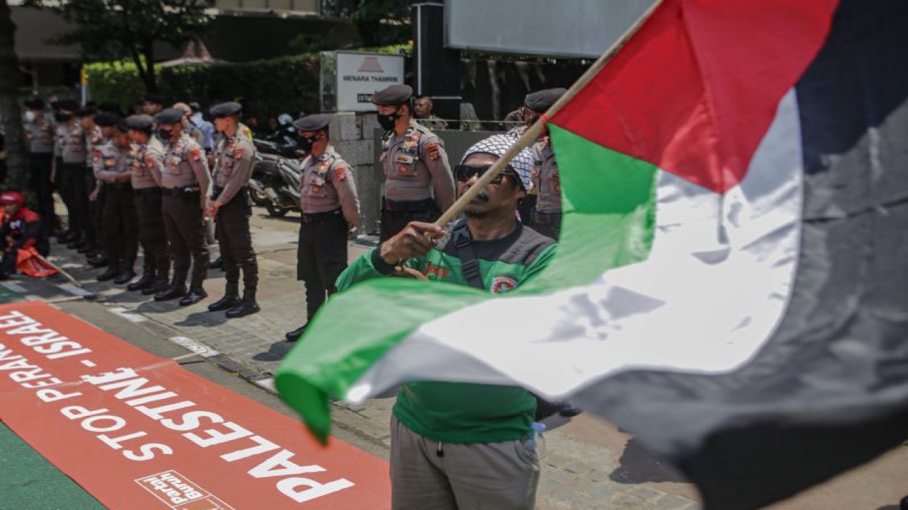 Pengunjukrasa mengibarkan bendera Palestina saat aksi stop perang Israel-Palestina di depan Kantor Perserikatan Bangsa-Bangsa (PBB), Jakarta, Selasa (10/10/2023). . ANTARA FOTO/Fauzan/YU (ANTARA FOTO/FAUZAN)
