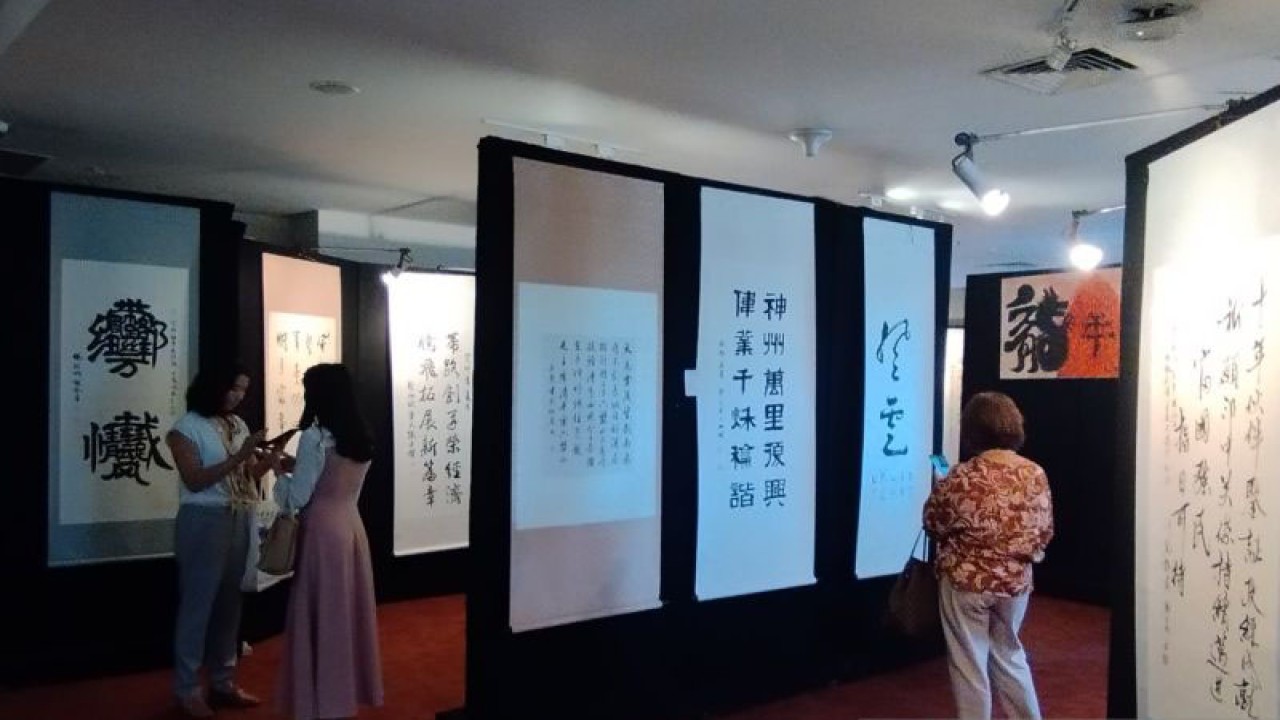 Pengunjung melihat kaligrafi China yang dipamerkan dalam pameran "The Fourth OCCA Calligraphy and Painting Exhibition" di Perpustakaan Nasional RI, Jakarta Pusat, Jumat (20/10/2023). ANTARA/Nabil Ihsan.