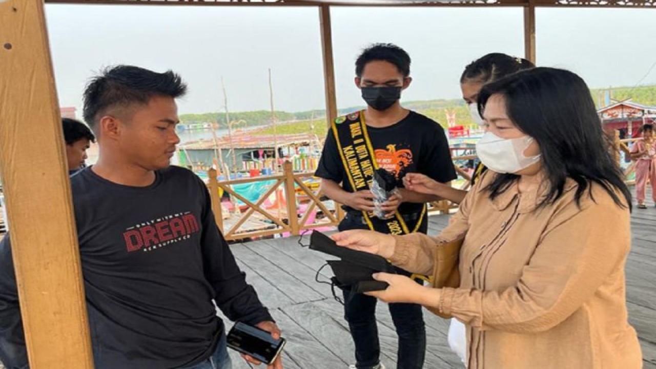 Disbudparpora membagikan masker kepada wisatawan di Kawasan Objek WIsata Kereng Bangkirai, Palangka Raya. (ANTARA/HO-Disbudparpora)