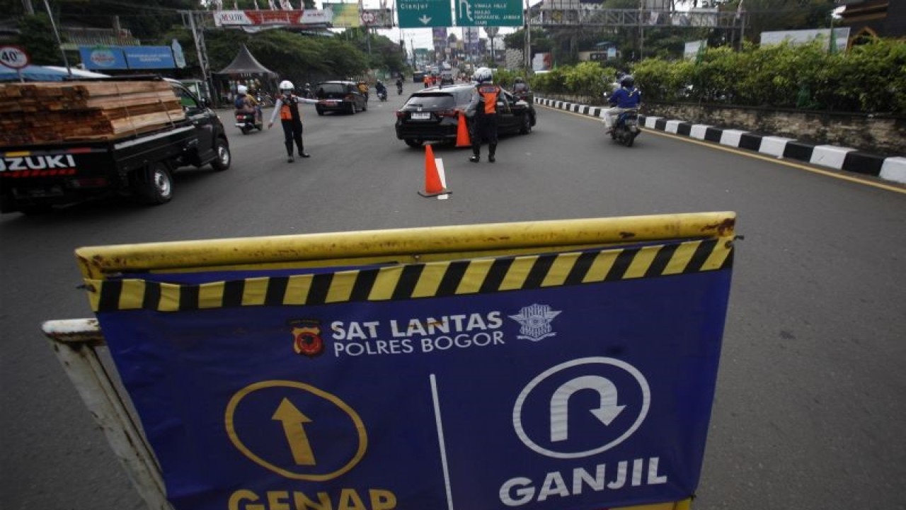Petugas Sat Lantas Polres Bogor dan petugas Dishub Kabupaten Bogor mengarahkan mobil wisatawan saat penyekatan kendaraan bernomor polisi ganjil genap di jalur wisata Puncak, Gadog, Kabupaten Bogor, Jawa Barat, Kamis (18/5/2023).ÊSat Lantas Polres Bogor memberlakukan sistem ganjil-genap bagi kendaraan bermotor menuju kawasan Puncak mulai Rabu (17/5) hingga Minggu (21/5). ANTARA FOTO/Yulius Satria Wijaya/tom. (ANTARA FOTO/YULIUS SATRIA WIJAYA)