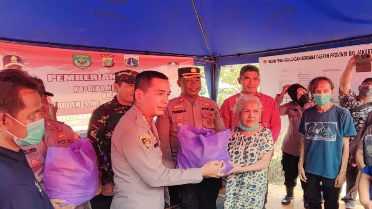 Kapolres Metro Jakarta Timur Kombes Pol Leonardus Simarmata saat menyerahkan bantuan secara simbolis kepada salah satu korban kebakaran di Jalan Kayu Jati V 42 RT 004/005 Kelurahan Rawamangun, Kecamatan Pulogadung, Jakarta Timur, Kamis (26/10/2023). ANTARA/Syaiful Hakim