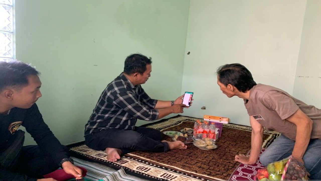 Petugas Reskrim Polresta Bogor Kota (menunjukan telepon seluler) saat mengunjungi rumah orang tua Noven Yohanes Bosco di Bandung pada Senin (2/10/2023). (ANTARA/HO/Polresta Bogor Kota)