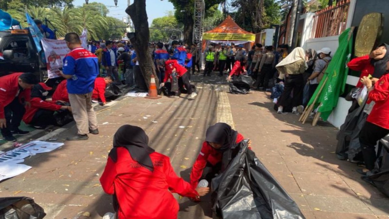 Relawan bakal capres Ganjar Pranowo dan cawapres Mahfud MD turut membersikan sampah usai pendaftaran capres-cawapres di sekitaran KPU RI, Jakarta, Kamis (19/1/2023). (ANTARA/HO-PDIP)