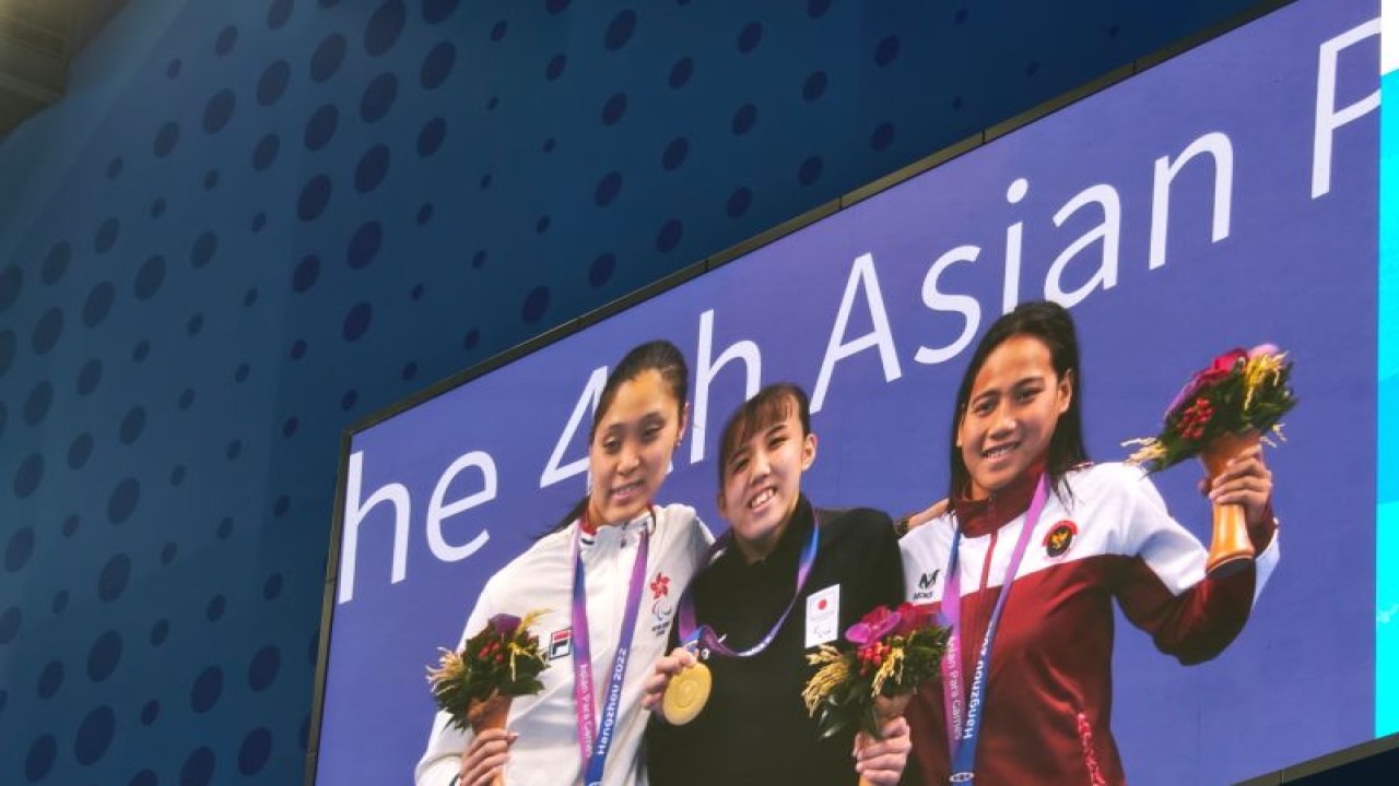 Syuci Indriani (Kanan) saat berdiri di podium Asian Para Games 2022 Hangzhou di HOC Aquatic Sports Arena, China, Rabu (25/10/2023). (ANTARA/HO/NPC Indonesia)