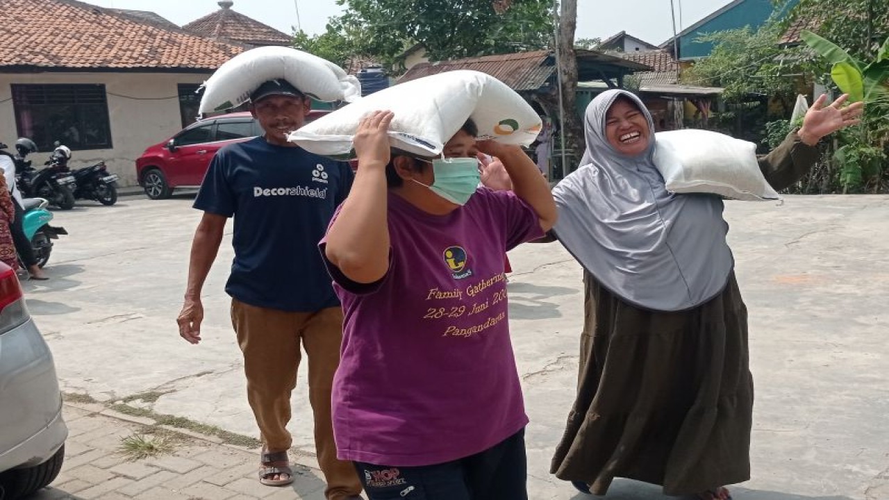 Tiga warga Rangkasbitung Kabupaten Lebak mengangkut beras program bantuan pangan sebanyak 10 kilogram yang digulirkan Badan Pangan Nasional. (ANTARA/Mansur).