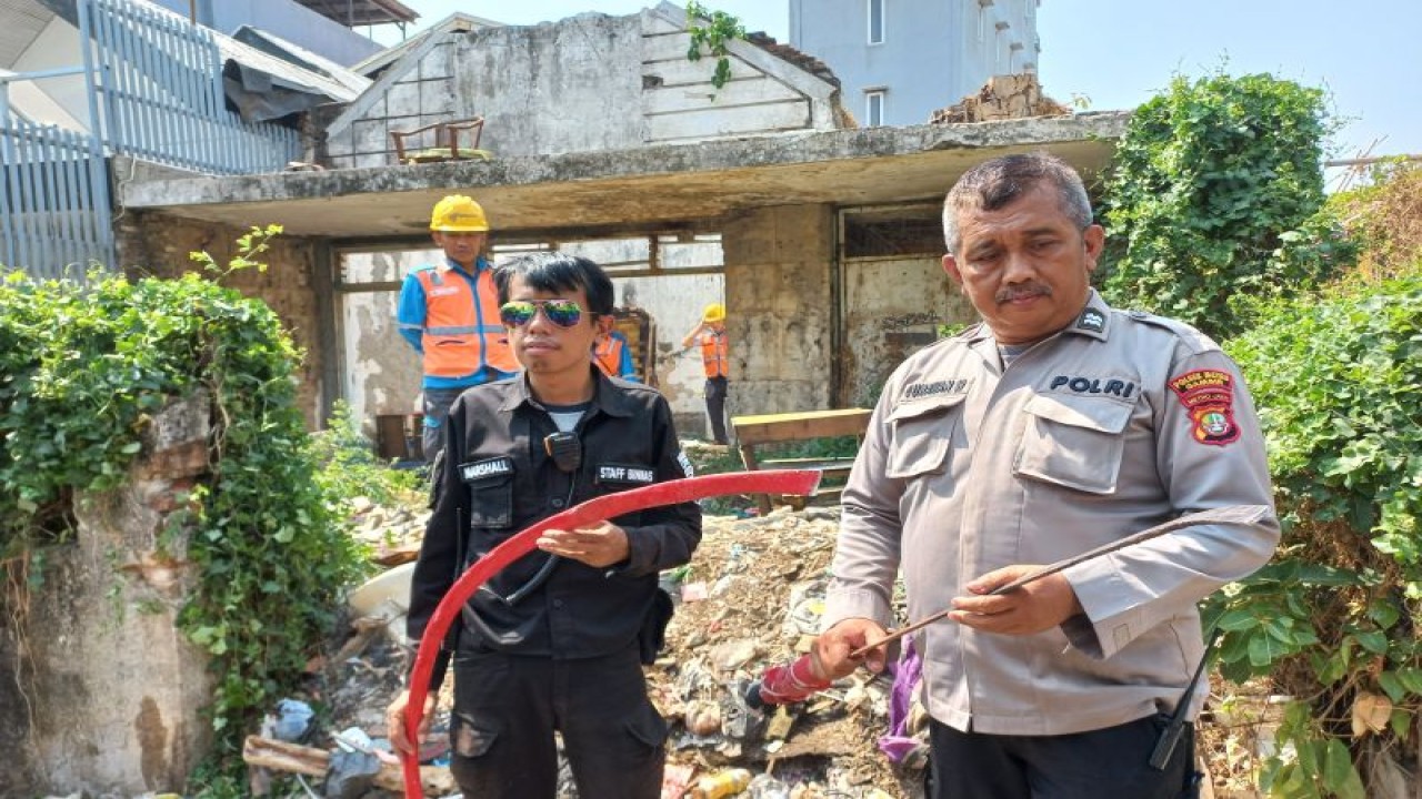 Kepala Sentra Pelayanan Kepolisian (KSPK) Polsek Metro Gambir Aiptu Gunawan menunjukkan benda mirip senjata tajam di lokasi kebakaran di Jalan Petojo Utara II, Petojo Utara, Jakarta Pusat, Selasa (10/10/2023). ANTARA/Nadia Putri Rahmani