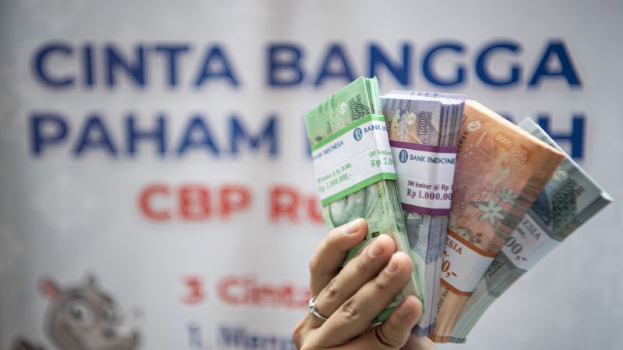 Warga menunjukkan uang baru tahun emisi 2022 usai melakukan penukaran di layanan kas keliling Bank Indonesia di Palembang, Sumatera Selatan, Selasa (28/3/2023). Untuk memenuhi kebutuhan masyarakat saat Ramadhan dan Idul Fitri Kantor Perwakilan Bank Indonesia Provinsi Sumatera Selatan menyediakan Rp3,8 triliun untuk layanan penukaran uang kecil di 145 titik yang bersinergi dengan perbankan di Sumatera Selatan. ANTARA FOTO/Nova Wahyudi/aww. (ANTARA FOTO/NOVA WAHYUDI)