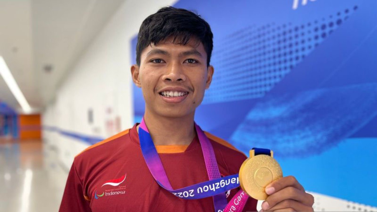 Sprinter Indonesia Saptoyogo Purnomo berpose dengan medali emas yang ia raih di nomor lari 200 meter T37 putra Asian Para Games 2022 Hangzhou di Huanglong Sports Centre Stadium, China, Rabu (25/10/2023). (ANTARA/Arnidhya Nur Zhafira)