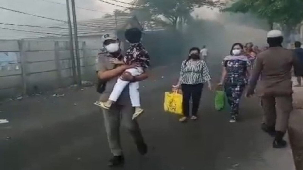 Petugas Satpol PP mengevakuasi warga ke kantor kecamatan dampak asap pekat dari kebakaran di TPA Rawakucing sabtu siang. HO/Pemkot Tangerang