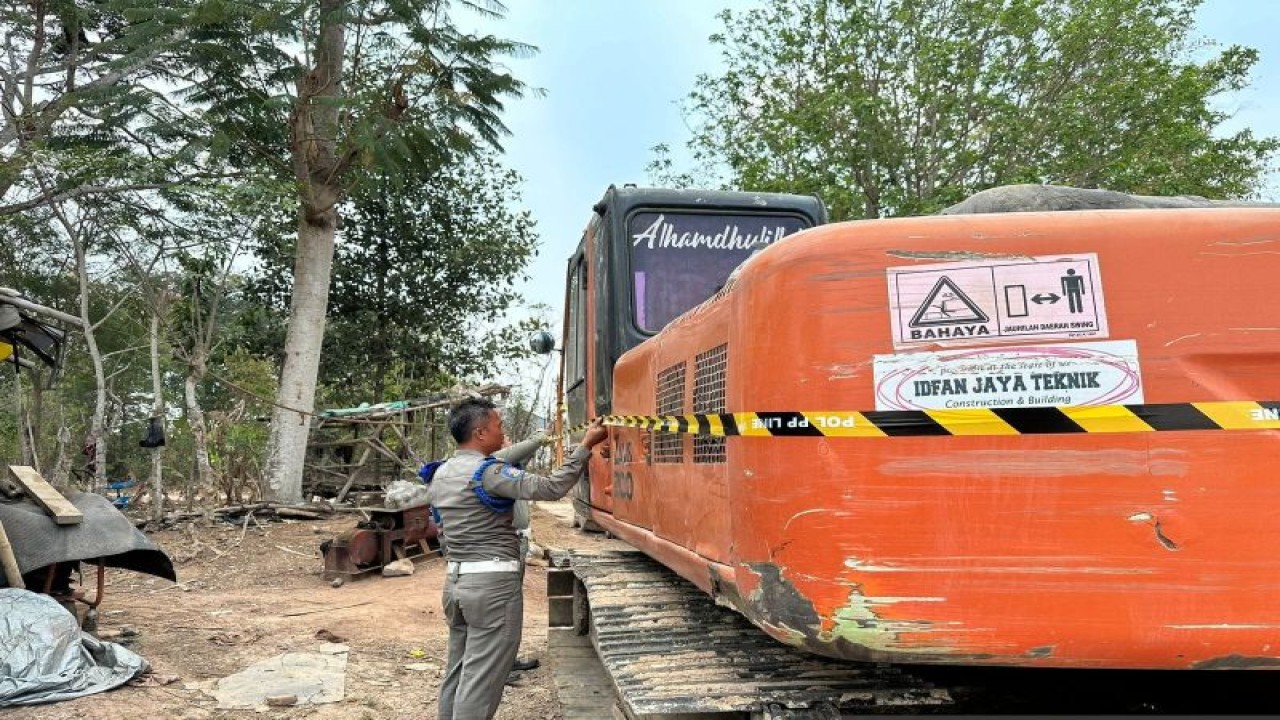 Petugas dari Satpol PP Kabupaten Tangerang saat melakukan pemasangan garis lane untuk penyegelan aktivitas galian tanah di daerahnya itu. (Azmi)