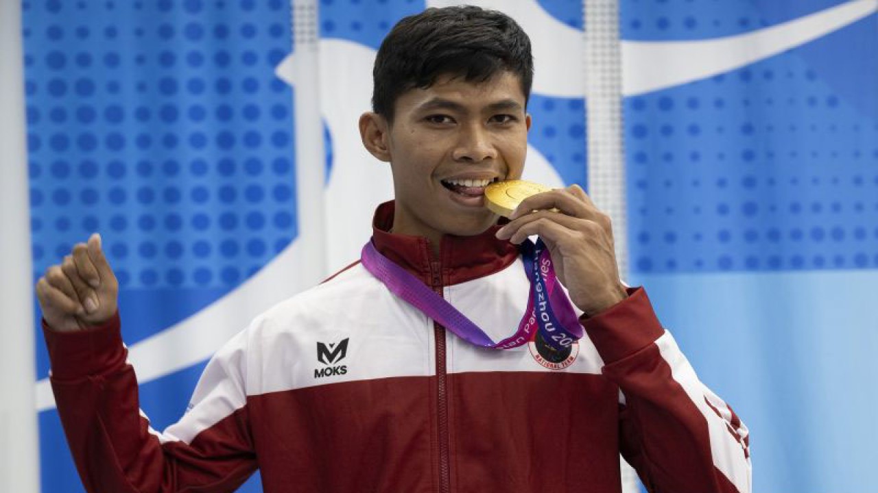 Pelari putra Indonesia Saptoyogo Purnomo berpose dengan medali emasnya usai upacara pengalungan medali nomor lari 400 meter T37 Asian Para Games 2022 di Hangzhou Olympic Sports Centre Stadium, Hangzhou, China, Senin (23/10/2023). Saptoyogo berhasil meraih medali emas pertama untuk Indonesia dengan catatan waktu 54,80 detik. ANTARA FOTO/NPC Indonesia/Josua Yulianto/mrh/nym.