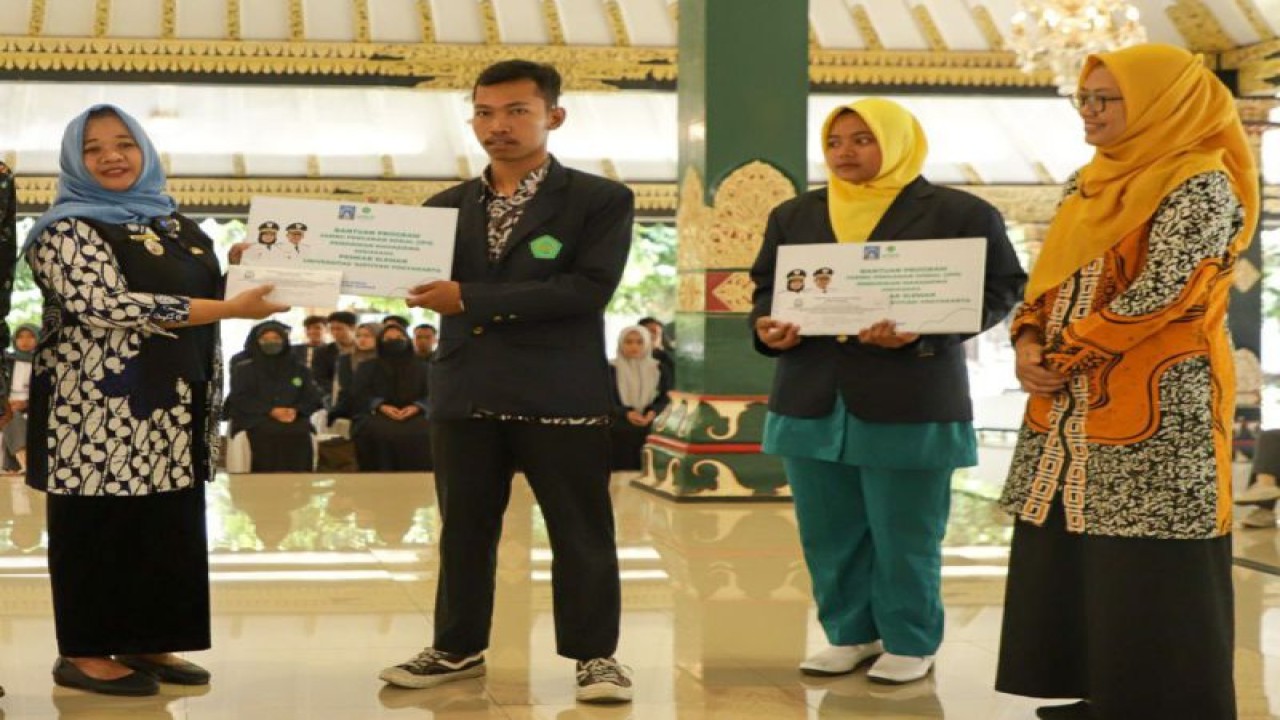 Bupati Sleman Kustini Sri Purnomo menyerahkan secara simbolis beasiswa bagi mahasiswa Sleman yang berasal dari keluarga miskin dan rentan miskin di Pendopo Parasamnya Setda Sleman, Rabu (11/10/2023). ANTARA/HO-Bagian Prokopim Setda Sleman