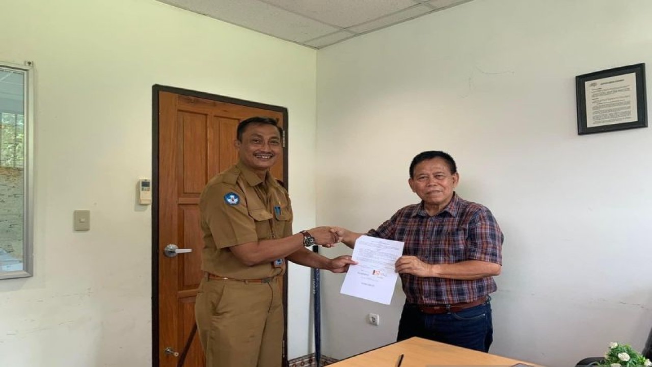 Kepala Sekolah SMK Negeri Lima Penerbangan Kabupaten Jayapura P Budi Riyanto dan Manager Adventist Aviation Molly Mambu memegang surat nota kesepakatan usai menandatangani kerja sama. (ANTARA/HO-Humas SMKN 5 Penerbangan)