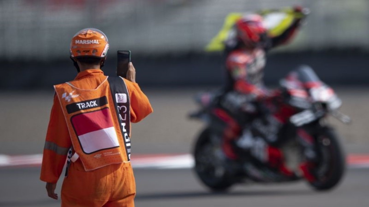 Marshal mendokumentasikan pembalap Aprilia Racing Maverick Vinales melakukan selebrasi usai berakhirnya balapan MotoGP seri ke-15 di Pertamina Mandalika International Street Circuit, Lombok Tengah, NTB, Minggu (15/10/2023). ANTARA FOTO/Wahyu Putro A/nz (ANTARA FOTO/WAHYU PUTRO A)