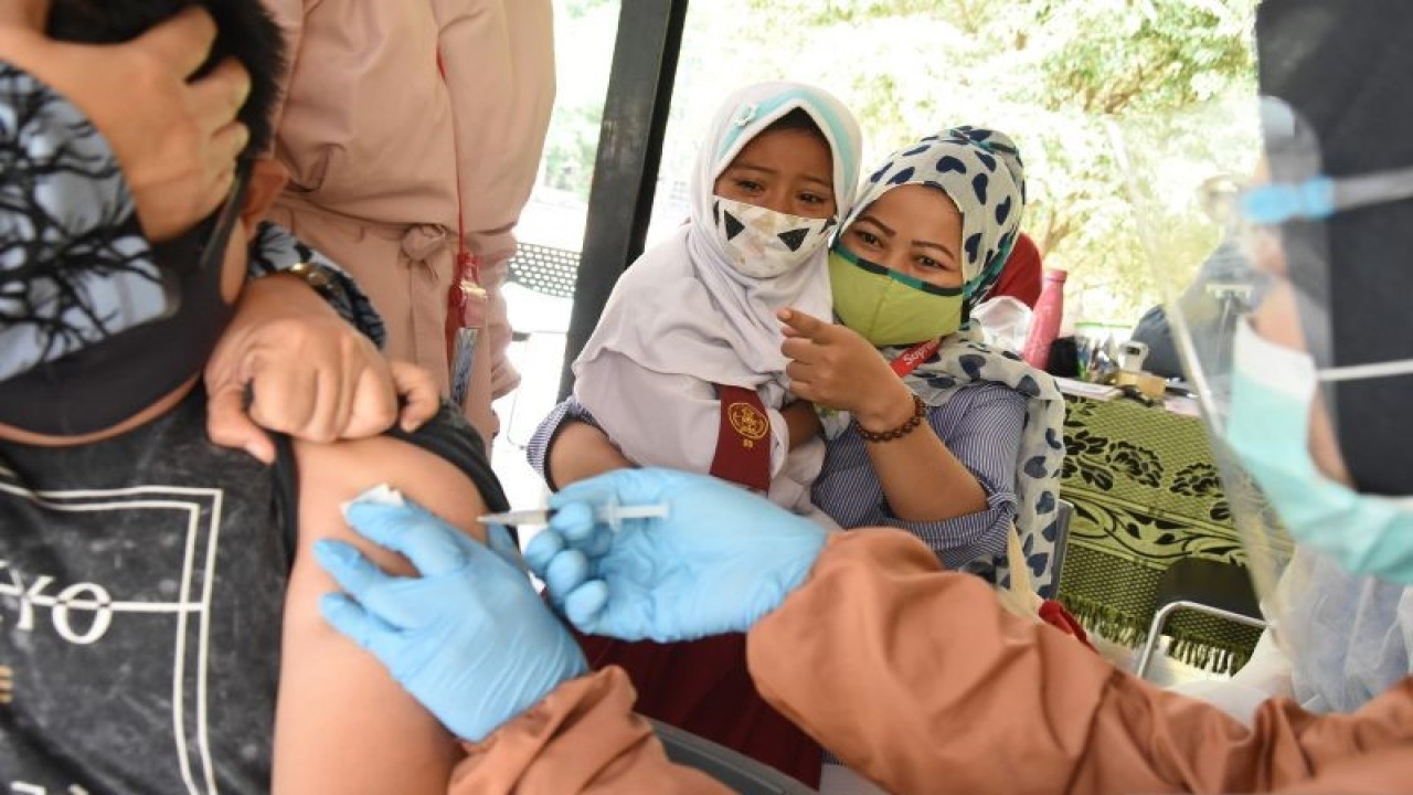 Seorang pelajar SD menangis saat akan mendapatkan suntikan imunisasi oleh petugas Puskesmas di RPTRA Teratai, Tebet, Jakarta, Selasa (20/10/2020). ANTARA FOTO/Indrianto Eko Suwarso/foc.