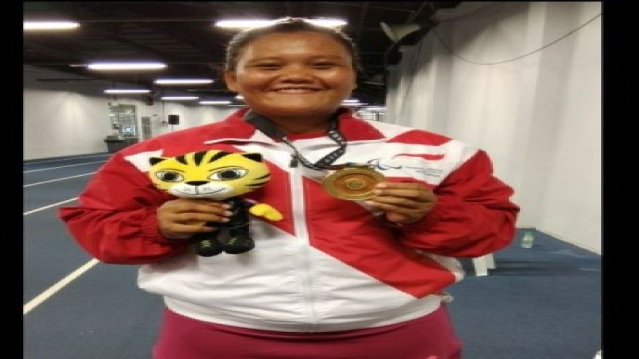 Atlet difabel Indonesia, Suparni Yati, berpose dengan medali emas ASEAN Para Games 2017 dari nomor tolak peluru F20 putri di Kuala Lumpur, Malaysia, Rabu (20/9/2017). (ANTARA/Michael Siahaan)