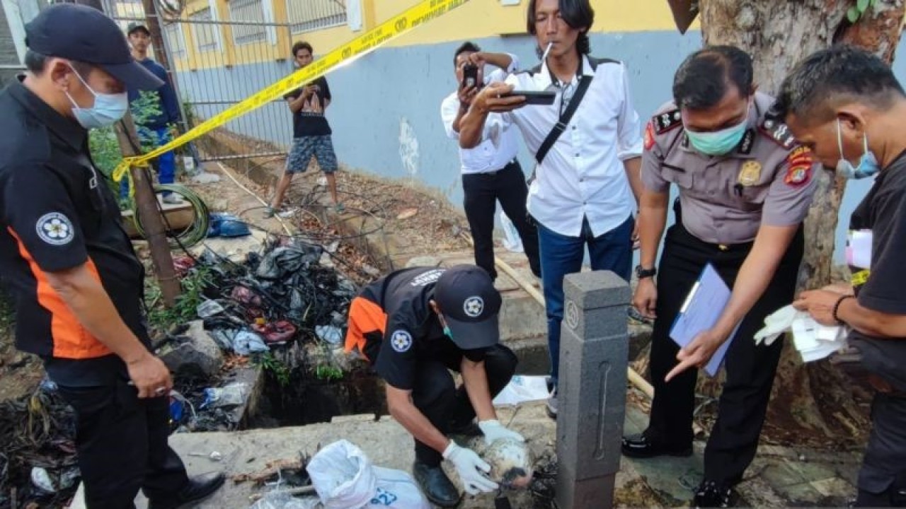 Petugas tengah mengevakuasi tengkorak manusia yang ditemukan di dalam selokan di depan kavling DKI Jalan Radin Inten II Kelurahan/Kecamatan Duren Sawit, Jakarta Timur, Senin (23/10/2023). (ANTARA/Syaiful Hakim)