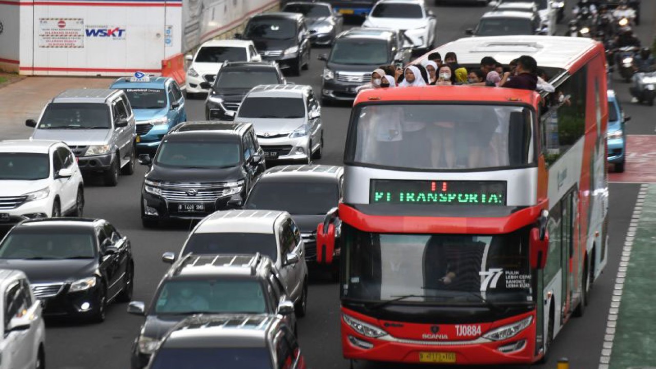 Warga menaiki Bus Wisata Transjakarta di Jalan Jenderal Sudirman, Jakarta, Jumat (20/1/2023). Bus tingkat dengan atap terbuka yang merupakan fasilitas gratis itu memungkinkan warga menikmati pemandangan lanskap gedung-gedung perkantoran di Ibu Kota. ANTARA FOTO/Hafidz Mubarak A/aww.