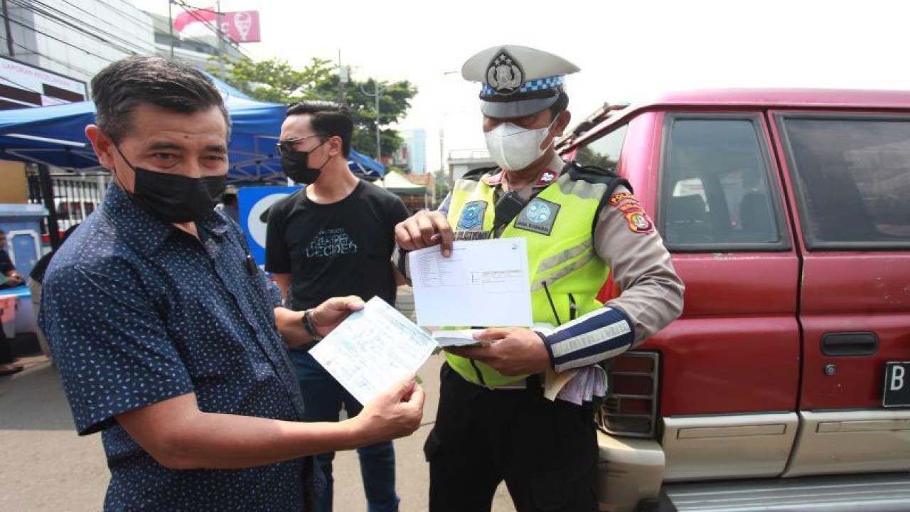 Petugas menilang pengendara kendaraan tak lolos uji emisi di Subdit Gakkum Ditlantas Polda Metro Jaya, Jakarta, Jumat (1/9/2023). . ANTARA FOTO/Reno Esnir/rwa.