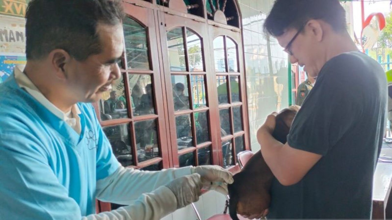 Seorang warga membawa hewan peliharaannya untuk divaksin di Jalan Benda, Kemayoran, Jakarta Pusat, Kamis (12/10/2023). ANTARA/Nadia Putri Rahmani