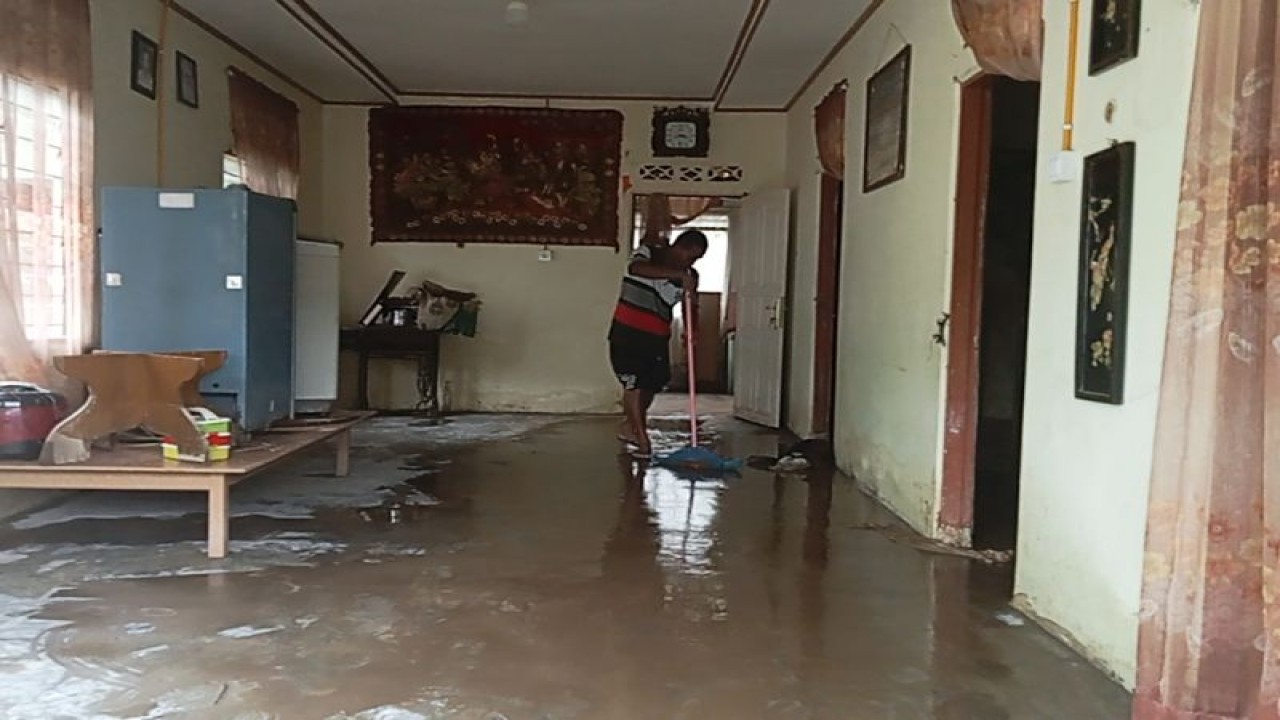Seorang warga terdampak banjir bandang di Nagari Durian Tinggi Kecamatan Lubuk Sikaping Kabupaten Pasaman membersihkan lumpur yang menggenangi rumahnya pada Selasa (17/10) pagi. Antara/Altas Maulana.