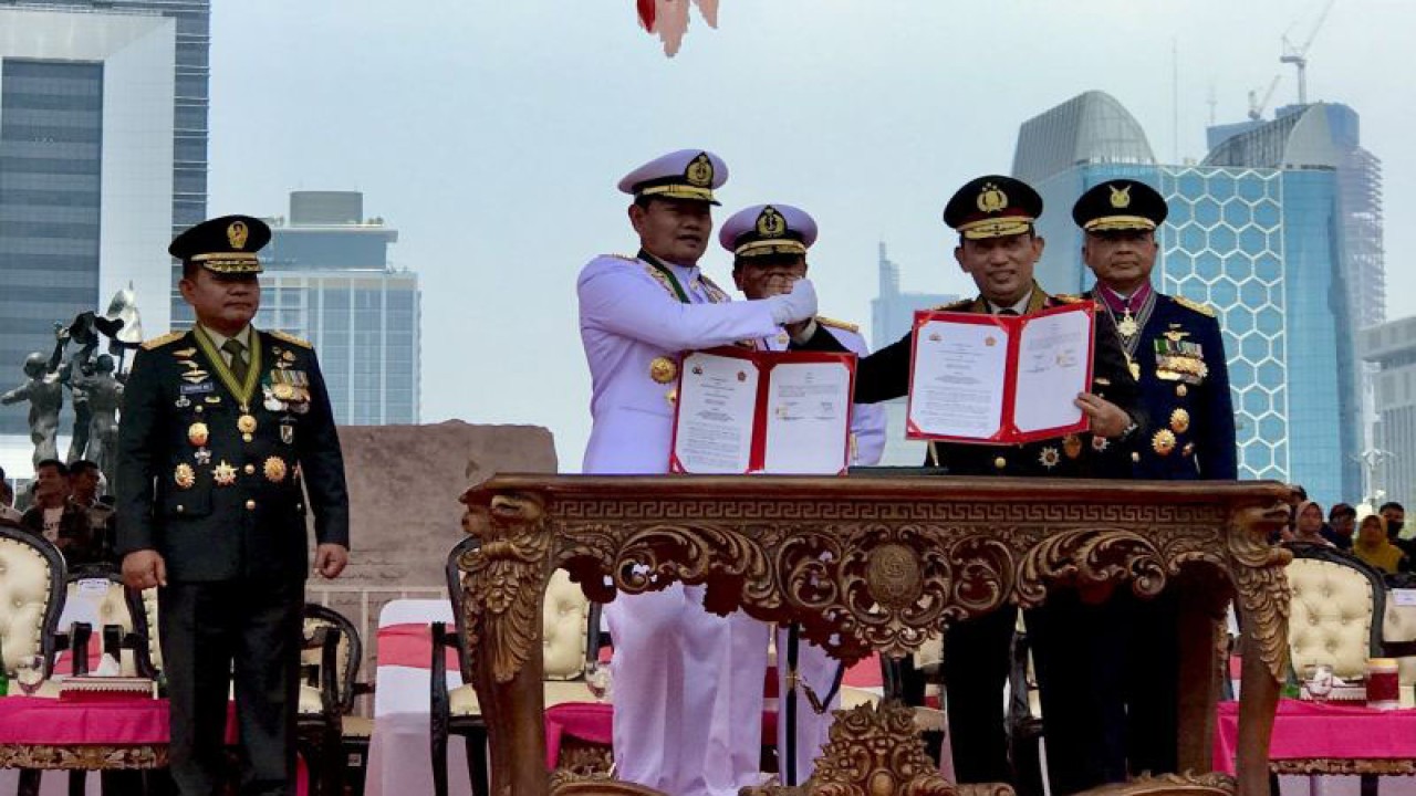 Panglima TNI Laksamana TNI Yudo Margono (dua kiri) berjabat tangan dengan Kapolri Jenderal Pol. Listyo Sigit Prabowo berjabat tangan selepas keduanya meneken dokumen nota kesepahaman kerja sama (MoU) sinergi TNI-Polri pada sela-sela Upacara Parade dan Defile HUT Ke-78 TNI di Monumen Nasional, Jakarta, Kamis (5/10/2023). ANTARA/Genta Tenri Mawangi.