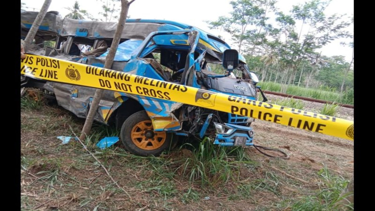 Polisi memberikan polce line pada minibus elf yang rusak parah dan sudah dievakuasi sejauh 20 meter dari rel KA di Desa Ranupakis, Kecamatan Klakah, Kabupaten Lumajang, Senin (20/11/2023). (ANTARA/HO-Tangkapan layar)