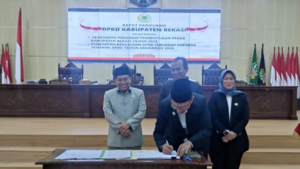 Penjabat Bupati Bekasi Dani Ramdan menandatangani berita acara keputusan bersama penetapan Anggaran Pendapatan dan Belanja Daerah (APBD) Kabupaten Bekasi Tahun Anggaran 2024, di Ruang Sidang Paripurna DPRD Kabupaten Bekasi, Jawa Barat, Selasa (28/11/2023) malam. ANTARA/Pradita Kurniawan Syah