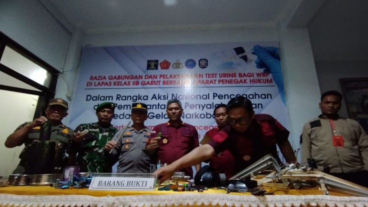 Kepala Lapas Kelas IIB Garut, Rusdedy (keempat kiri) bersama perwakilan dari instansi lainnya menunjukkan barang bukti hasil penggeledahan kamar narapidana di Lapas Kabupaten Garut, Jawa Barat, Kamis (23/11/2023) malam. (ANTARA/Feri Purnama)