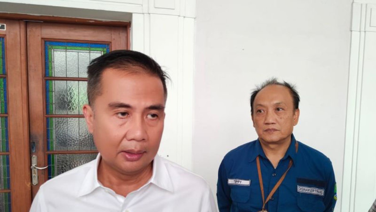 Penjabat (Pj) Gubernur Jawa Barat Bey Triadi Machmudin didampingi Kepala Dinas Tenaga Kerja dan Transmigrasi (Disnakertrans) Jawa Barat Teppy Wawan Dharmawan (kanan) memberikan keterangan di Gedung Sate Bandung, Selasa (14/11/2023). (ANTARA/Ricky Prayoga)