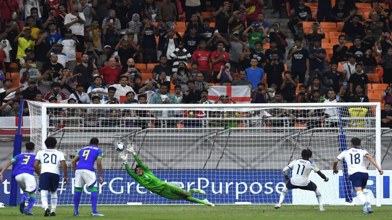 Penjaga gawang Timnas Brazil Phillipe Gabriel (keempat kiri) mencoba menangkap bola dari tendangan pinalti yang dieksekusi pesepak bola Timnas Inggris Joel Ndala (kedua kanan) dalam penyisihan Grup C Piala Dunia U-17 2023 di Jakarta International Stadium, Jakarta, Jumat (17/11/2023). Brazil berhasil mengalahkan Inggris dengan skor 2-1. ANTARA FOTO/Sigid Kurniawan/Spt.