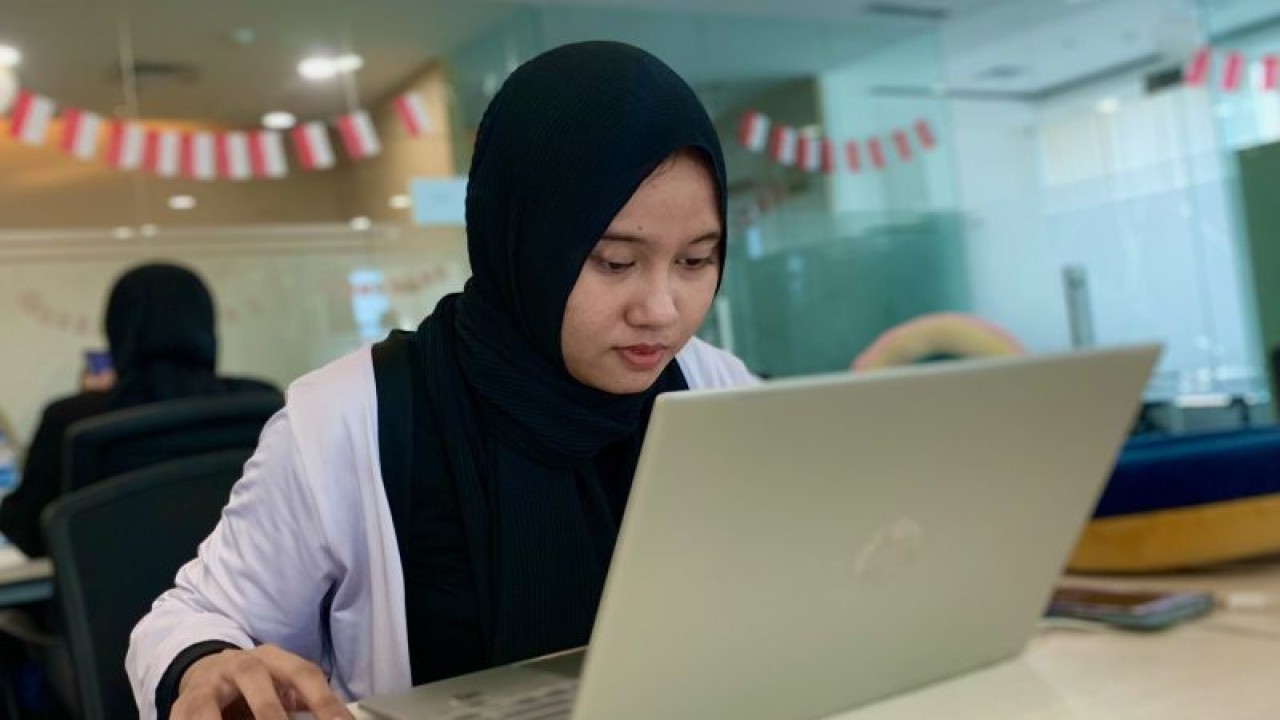 Seorang pemudi menyelesaikan pekerjaan menggunakan komputer jinjing di salah satu perusahaan di Jakarta, Selasa (14/11/2023). ANTARA/Cahya Sari.