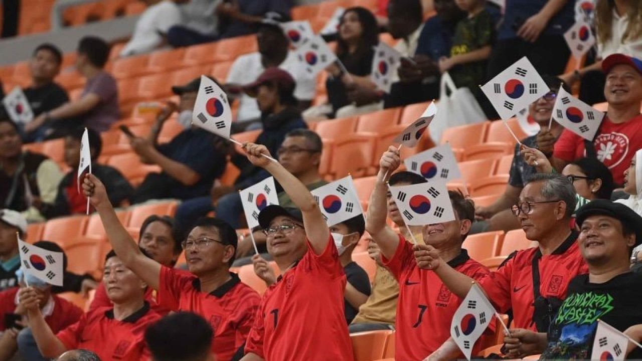 Pendukung Timnas Korea Selatan melambaikan bendera saat laga antara Prancis lawan Korea Selatan dalam penyisihan Grup E Piala Dunia U-17 di Jakarta International Stadium, Jakarta, Rabu (15/11/2023). ANTARA FOTO/Akbar Nugroho Gumay/YU