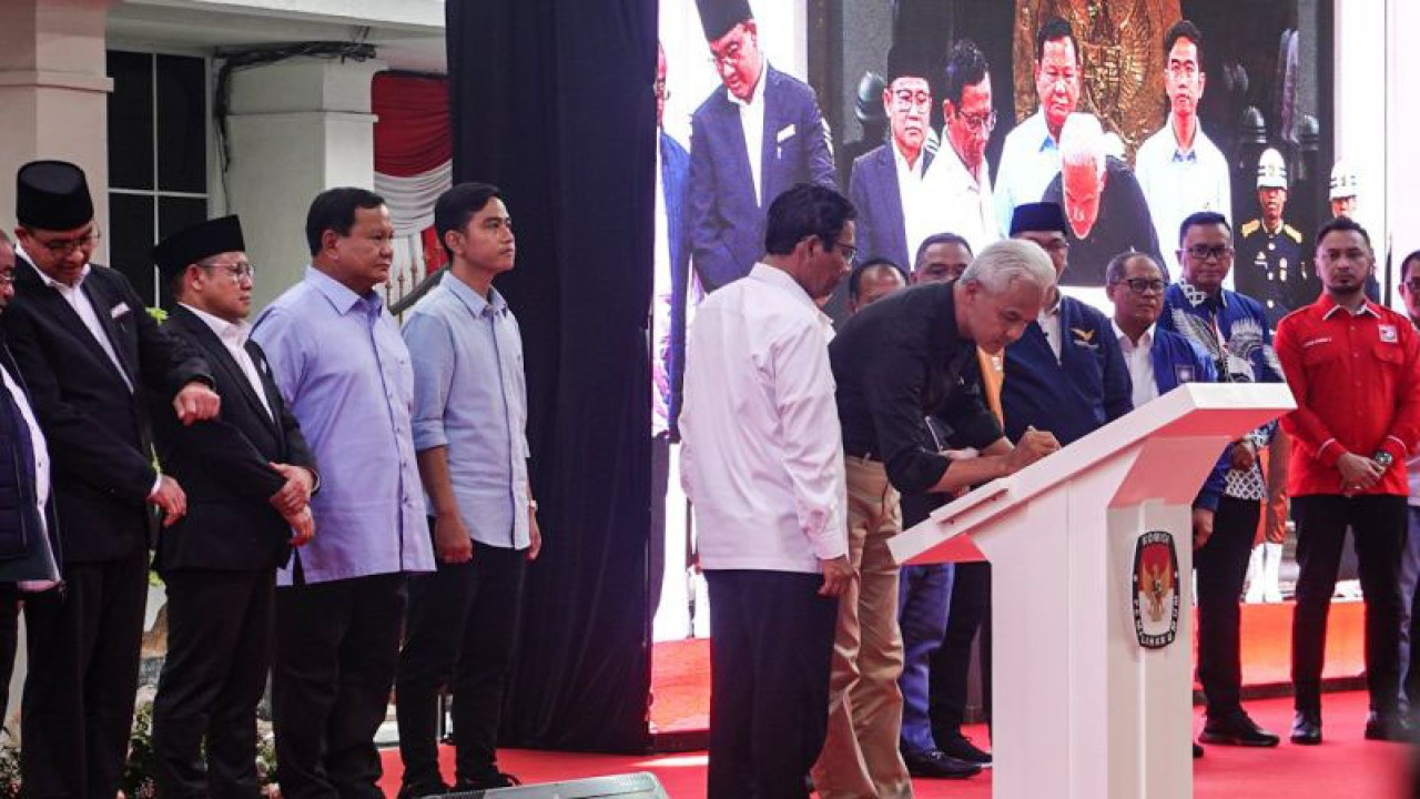 Pasangan calon presiden dan wakil presiden nomor urut 3, Ganjar Pranowo-Mahfud MD, saat menandatangani naskah Deklarasi Kampanye Pemilu Damai Tahun 2023 di Gedung KPU RI, Jakarta, Senin (27/11/2023). (ANTARA/Aprillio Abdullah Akbar)