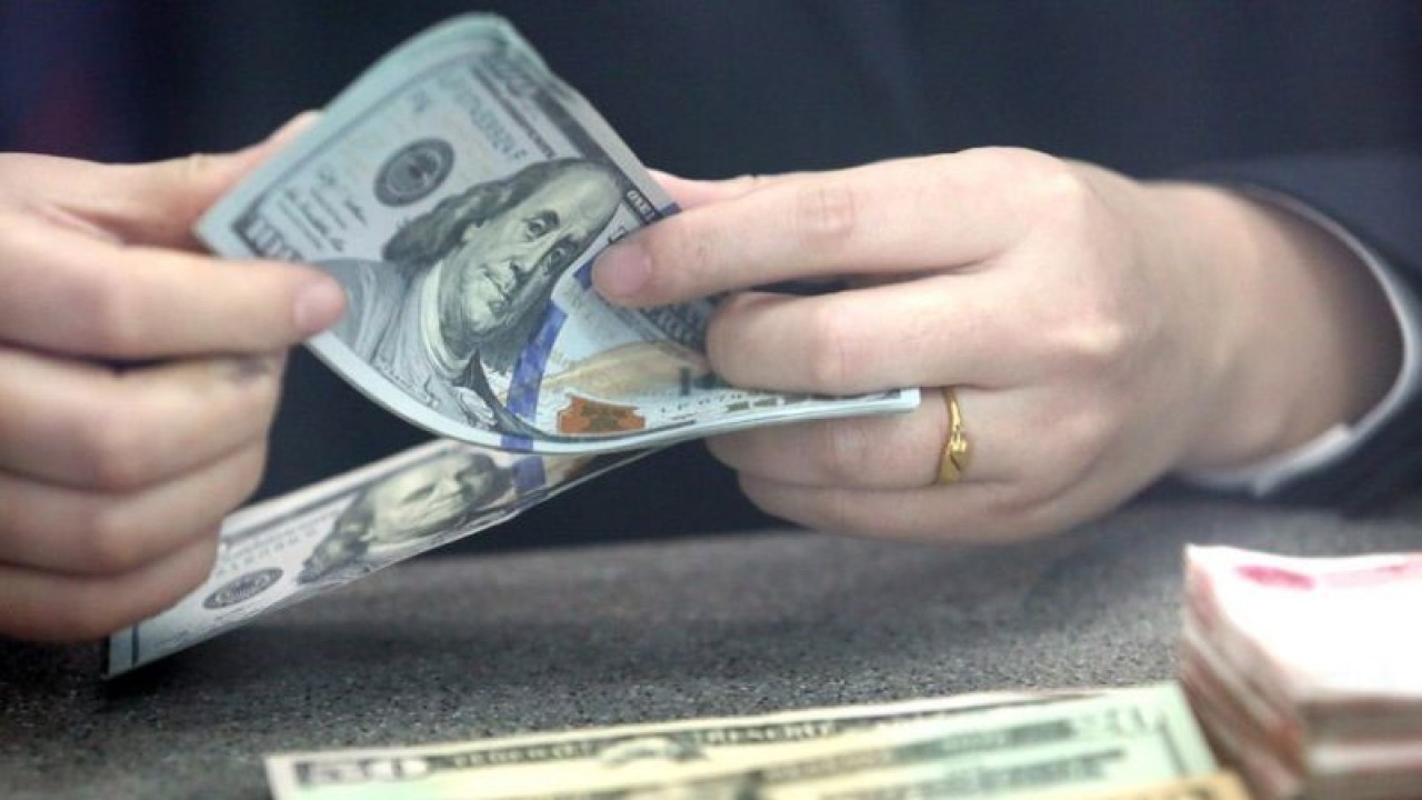 Seorang staf bank menghitung uang kertas dolar AS di sebuah bank di Tancheng Kota Linyi, Provinsi Shandong, China timur. ANTARA/Xinhua/Zhang Chunlei/am.
